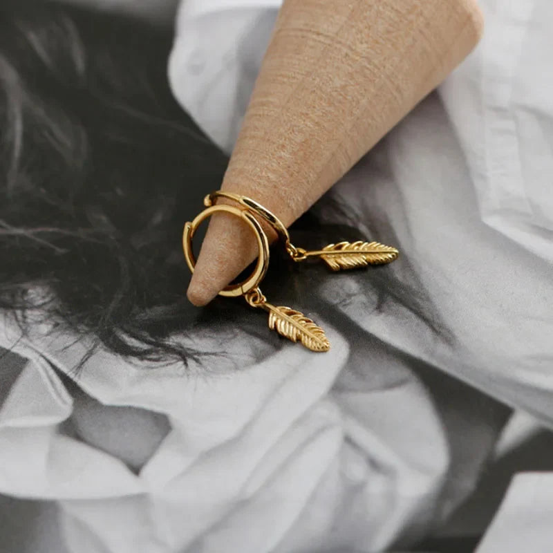 Gold hoop earrings with small dangling feather