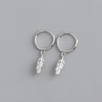 Silver hoop earrings with small dangling feather