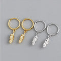 Gold hoop earrings with small dangling feather