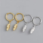 Gold hoop earrings with small dangling feather