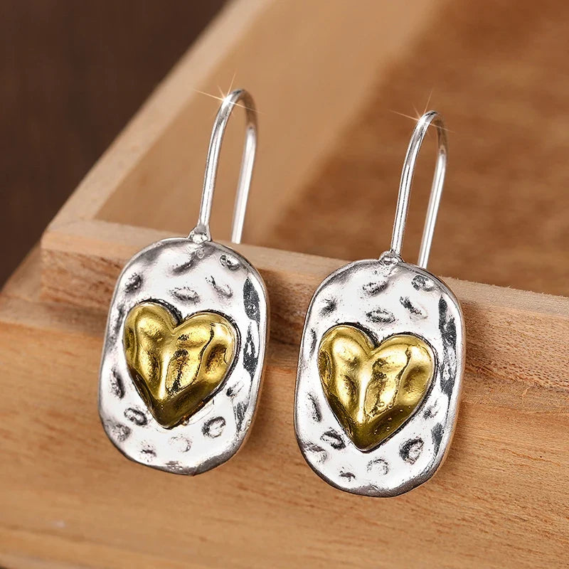 Silver and gold colored heart earrings