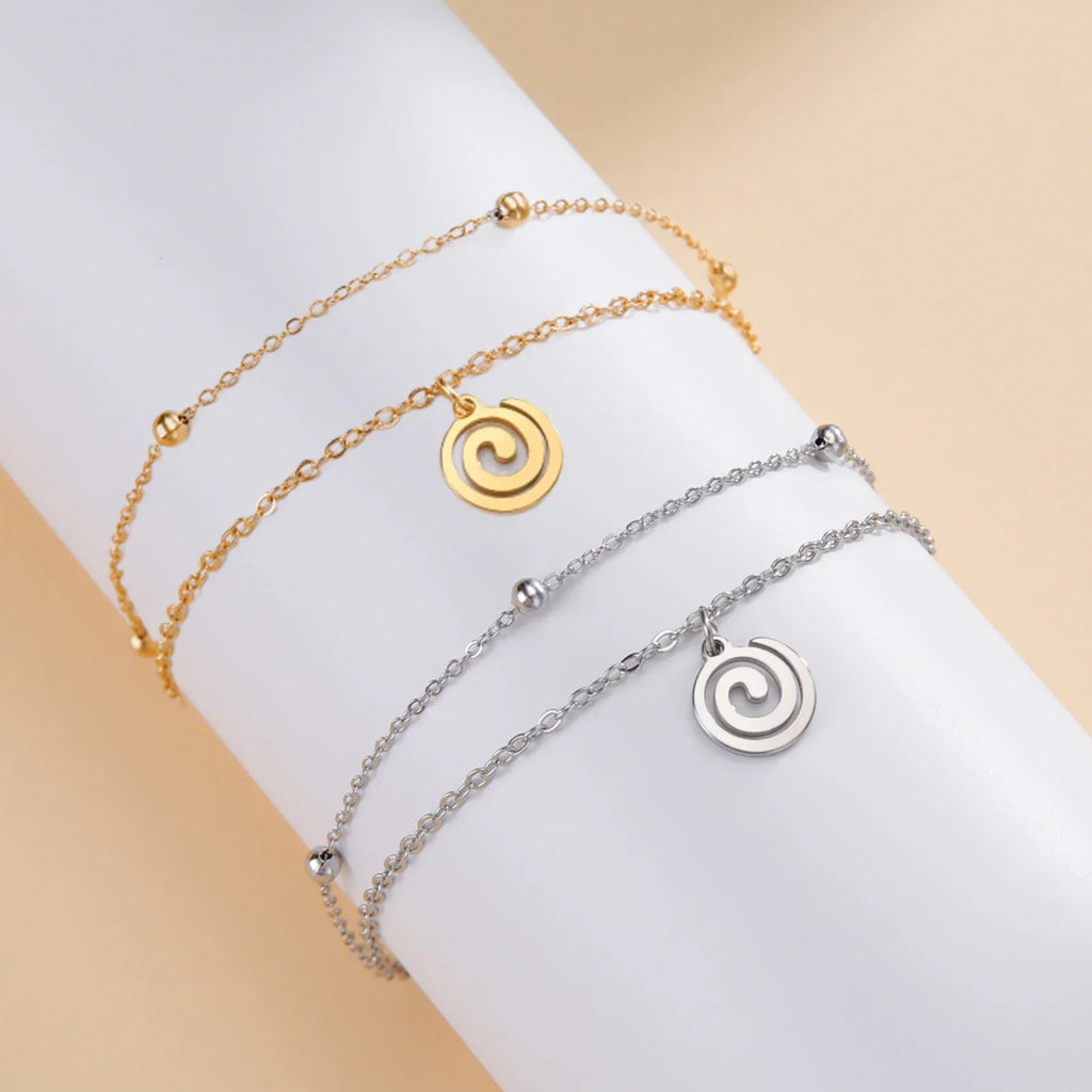 Gold-tone bracelet with small gold spiral charm