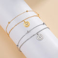 Gold-tone bracelet with small gold spiral charm