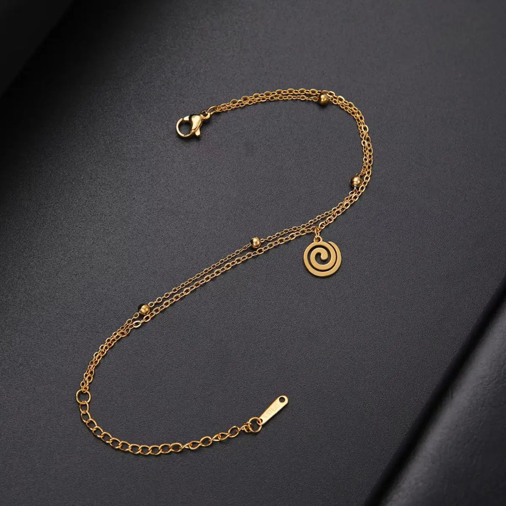 Gold-tone bracelet with small gold spiral charm