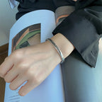 Open bangle bracelet with silver-plated feather