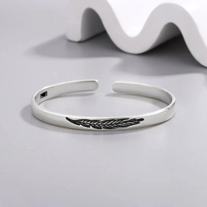Open bangle bracelet with silver-plated feather