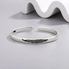Open bangle bracelet with silver-plated feather