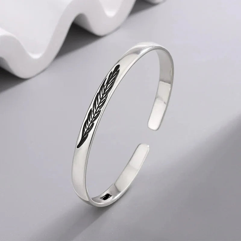 Open bangle bracelet with silver-plated feather
