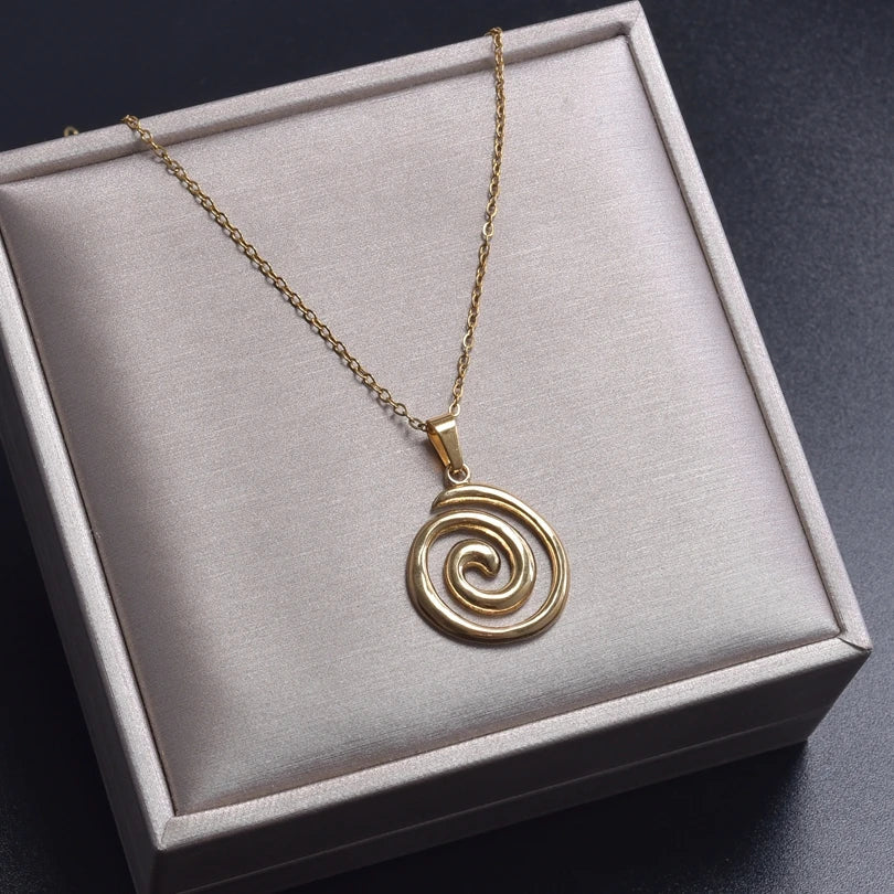 Necklace with large openwork spiral pendant in gold tone