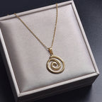 Necklace with large openwork spiral pendant in gold tone