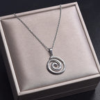 Necklace with large openwork spiral pendant in silver tone