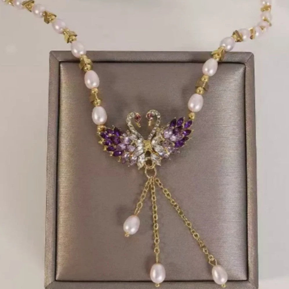 Purple necklace with two swans in the shape of a heart