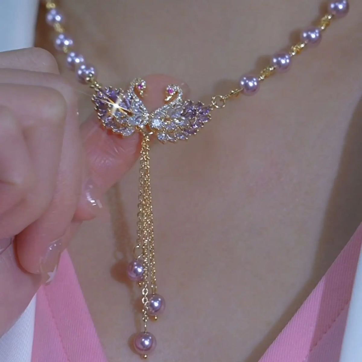 Purple necklace with two swans in the shape of a heart