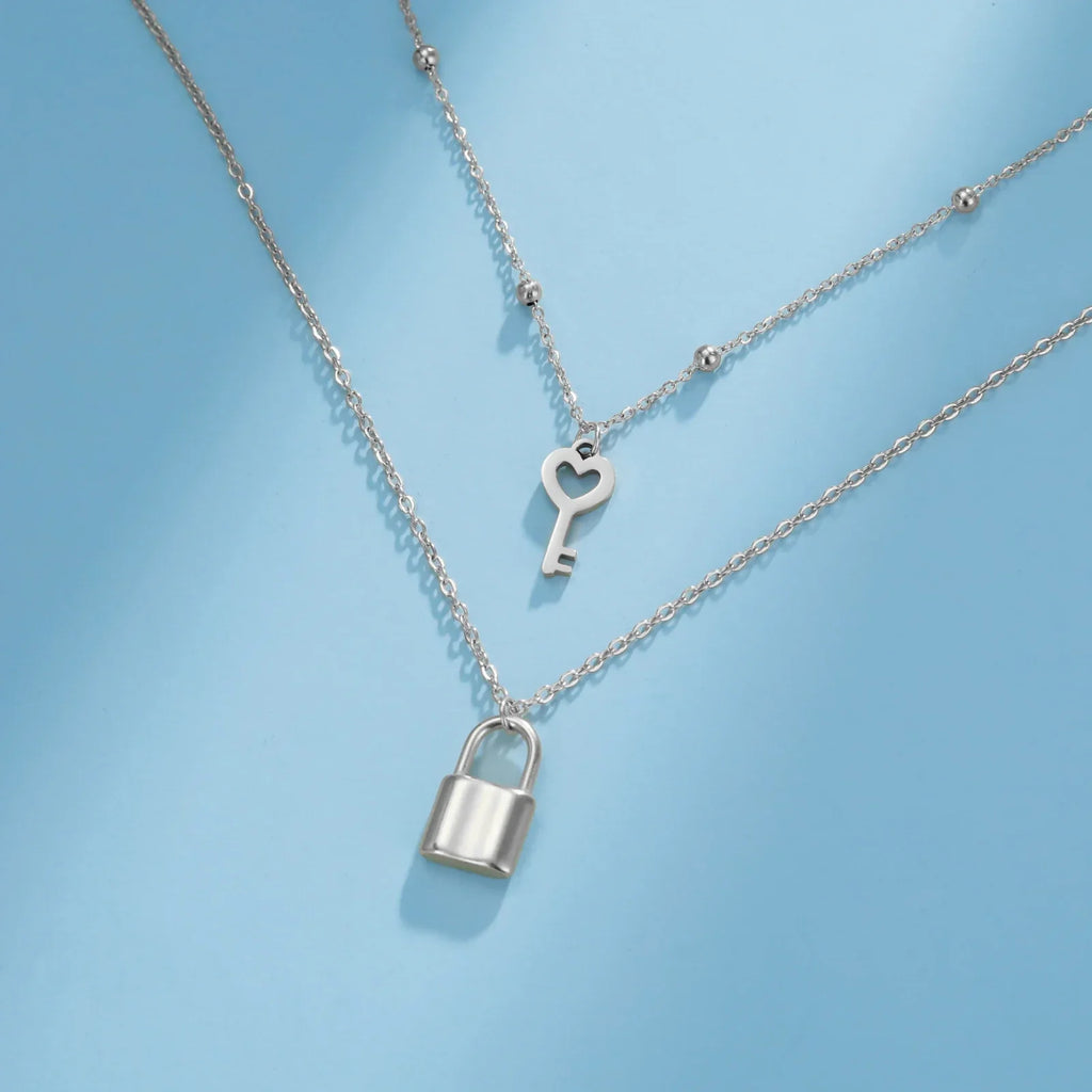 Double necklace with key and padlock pendant in silver tone