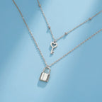 Double necklace with key and padlock pendant in silver tone