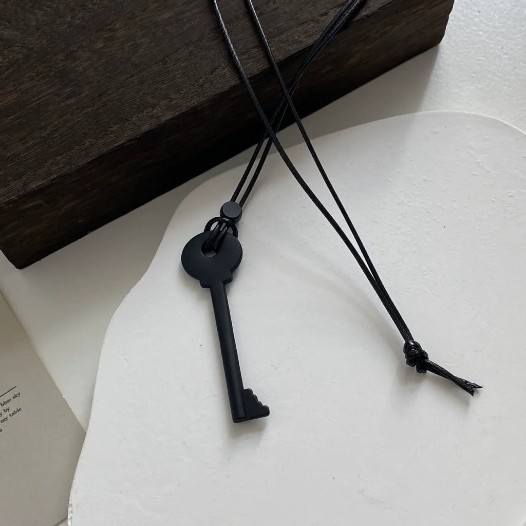 Long cord necklace with black key pendant
