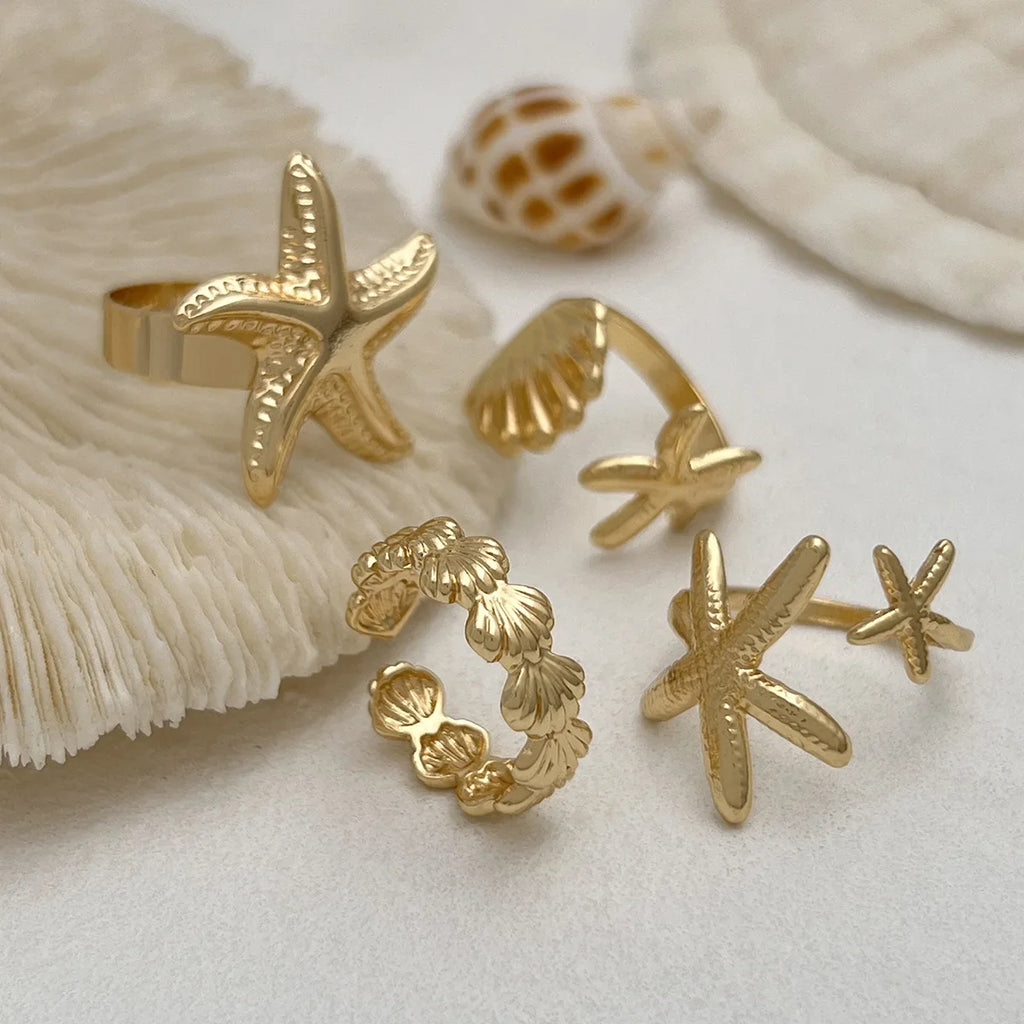 Set of 4 shell and starfish rings in gold