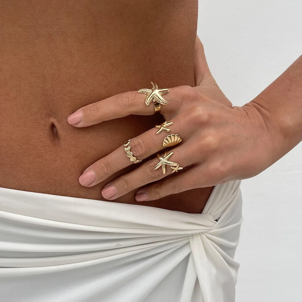 Set of 4 shell and starfish rings in gold
